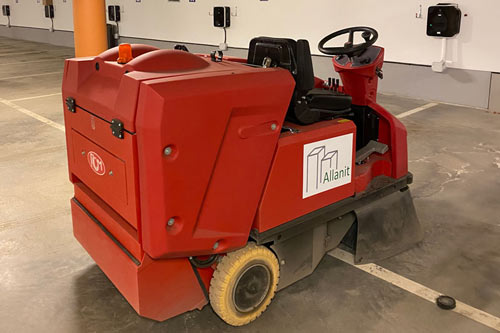 En sopmaskin som står i ett garage.